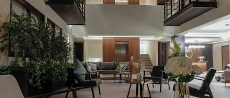 A spacious, multi-level living area with modern furniture, a staircase, and a skylight.