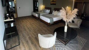 Una habitación de hotel moderna con una cama grande, dos mesitas de noche, un escritorio y una silla.