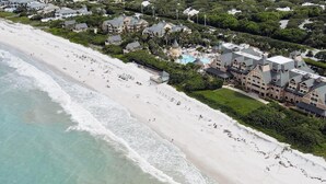 A coastal resort with a beachfront, multiple buildings, and a swimming pool.