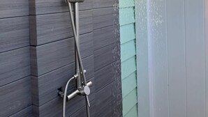 A showerhead with a handheld wand, a flexible hose, and a control knob.