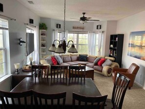Cozy living room with a dining table, comfortable sofa, and bookshelf.