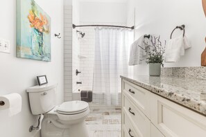 Ein modernes Badezimmer mit Toilette, Waschbecken und Duschbereich.