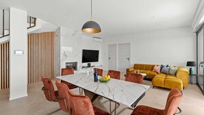 Un espacio habitable moderno con comedor, sofá y televisor.