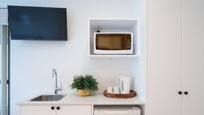 A compact kitchenette with a built-in microwave, a sink, and a small potted plant. - Bicheno Ocean Views Apt 2 - Bicheno Accommodation (Bicheno)