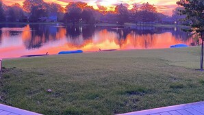Une vue paisible sur un lac, avec une terrasse en bois au premier plan.