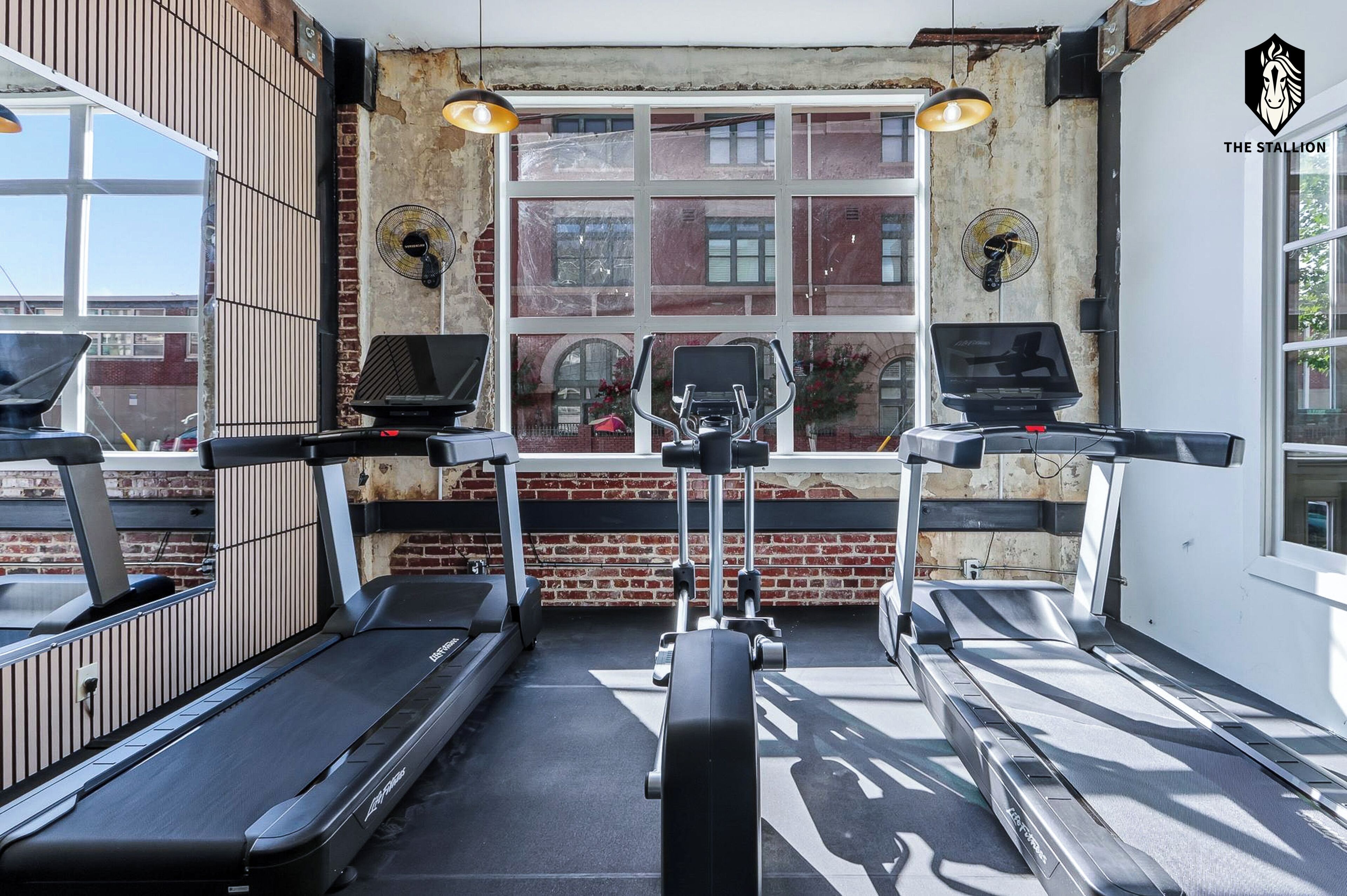 A gym with treadmills, stationary bikes, and a rowing machine.