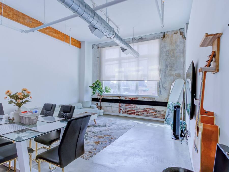 A modern office space with a glass table, black chairs, and a large window.