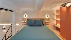 A modern bedroom with a bed, bedside tables, and built-in shelving.