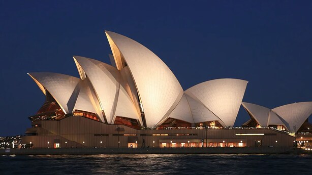 The Sydney Opera House with its distinctive sail-like design, multiple levels, and waterfront location.