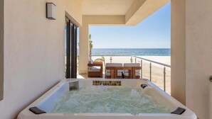 A hot tub with a view of the beach and ocean.