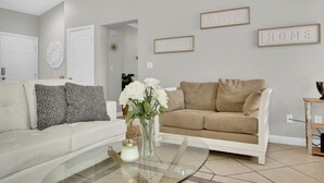 A modern living room with two sofas, a glass coffee table, and decorative items. - Henderson escape+ mini golf +peaceful stay (Henderson)