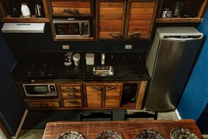 A compact kitchen with a microwave, toaster, and refrigerator. - Surfway Ilha do Mel (Paranaguá)