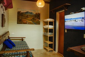A room with a bed, a TV, a shelf, and a painting. - Surfway Ilha do Mel (Paranaguá)