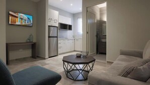 Un salon moderne avec un canapé, une table basse et un téléviseur fixé au mur.
