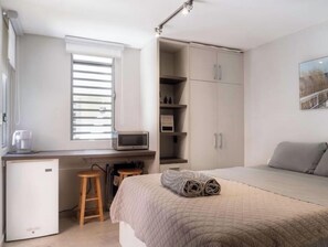 1 habitación, escritorio, tabla de planchar con plancha y cuna de viaje 