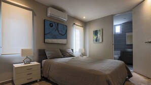 A bedroom with a bed, nightstands, a wall-mounted air conditioner, and a window. - Old San Juan Guesthouse.Free Parking, Rooftop & Generator – Casa Terra Porto #8 (San Juan)