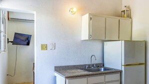 A compact kitchen with a sink, cabinets, and a refrigerator. - Beach House Walk To The Beach #2

 (San Juan)