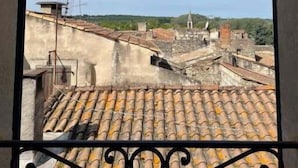 A view from a balcony with a tiled roof and a metal railing. - Maison Cosy Lodge, 15 p, clim, wifi, cour, garage (Montfrin)