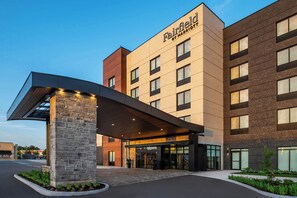 A Fairfield by Marriott hotel with a modern entrance, stone pillars, and a flat roof over the entrance.
