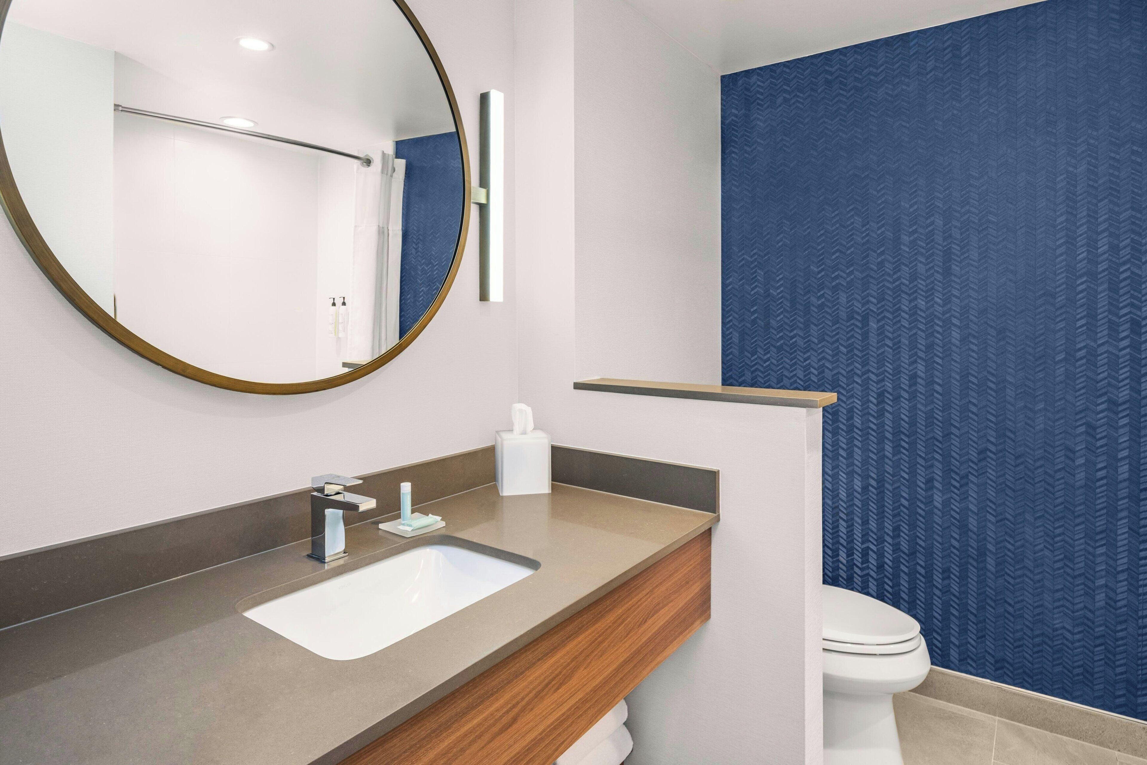 A bathroom with a modern sink, mirror, and toilet.