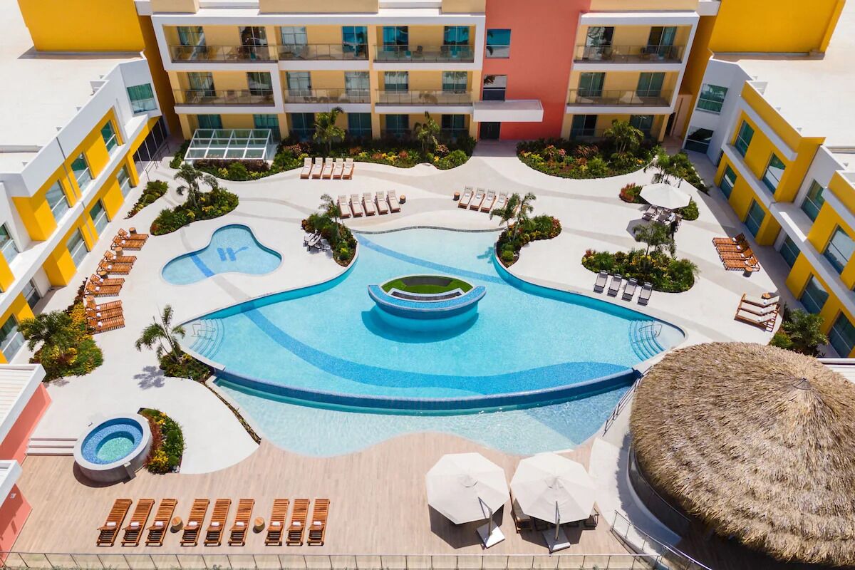 Dive into a sunlit lagoon pool surrounded by loungers.