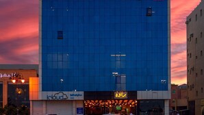 Un edificio moderno con fachada de vidrio y un letrero en árabe.