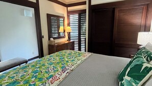 Une chambre d’hôtel avec un lit, une table de chevet, une lampe et une fenêtre avec des stores.