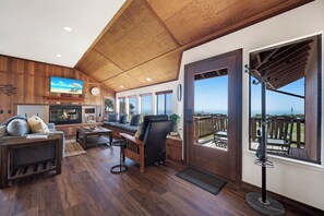 A cozy living room with a fireplace, comfortable seating, and a large TV.