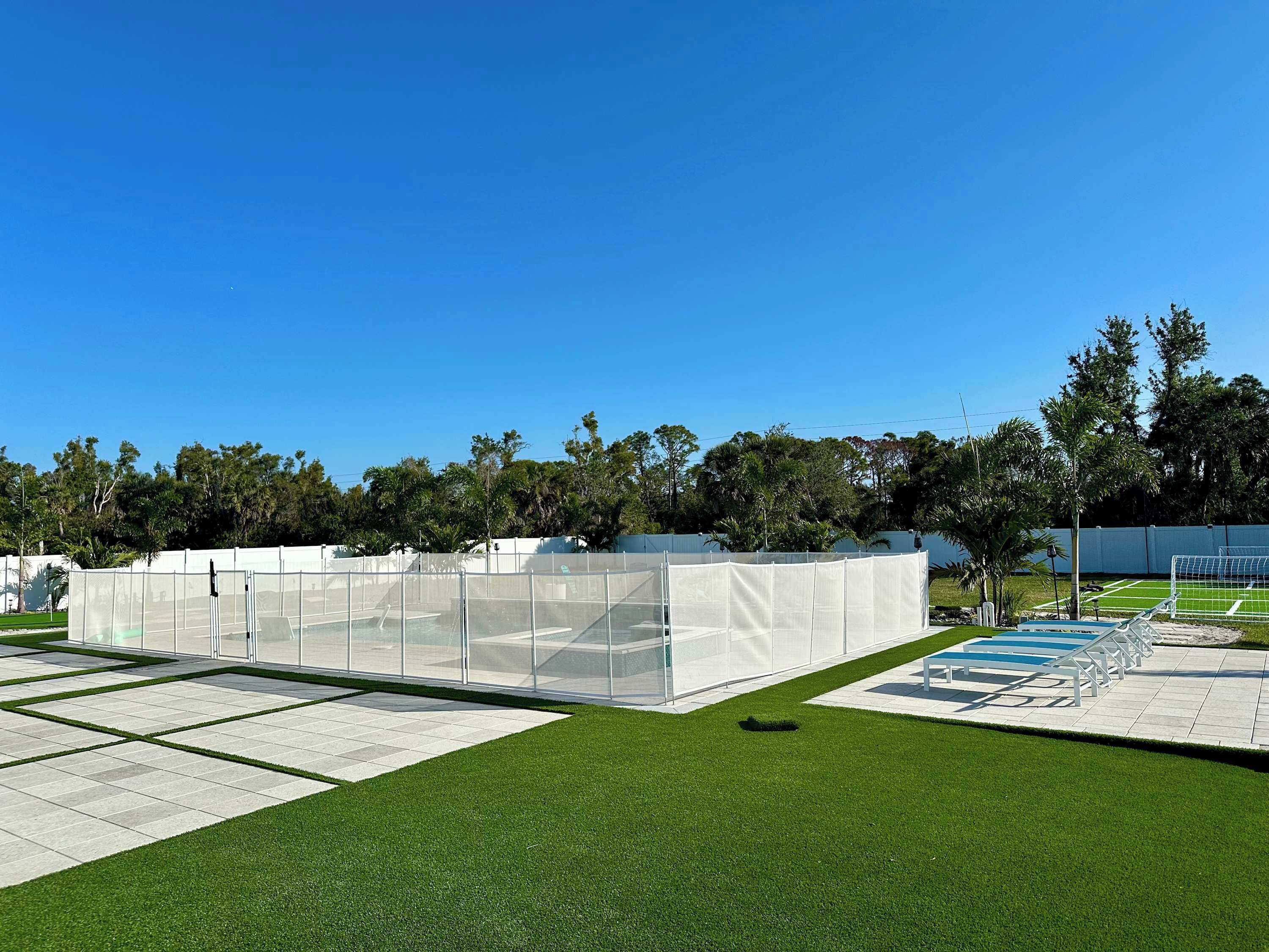 Un campo deportivo con césped artificial, una zona vallada y un arco.