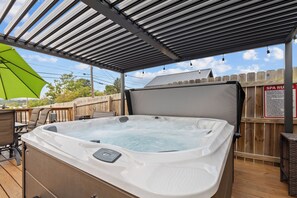 A hot tub with a control panel, under a covered patio area with a wooden fence and a sign. - Bristol Abode w Hot Tub, Firepit, Dogs OK (Bristol)