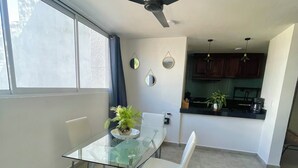Una cocina moderna con armarios oscuros, una cafetera y una planta en maceta.