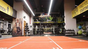 A gym with orange running tracks, weightlifting equipment, and motivational posters.