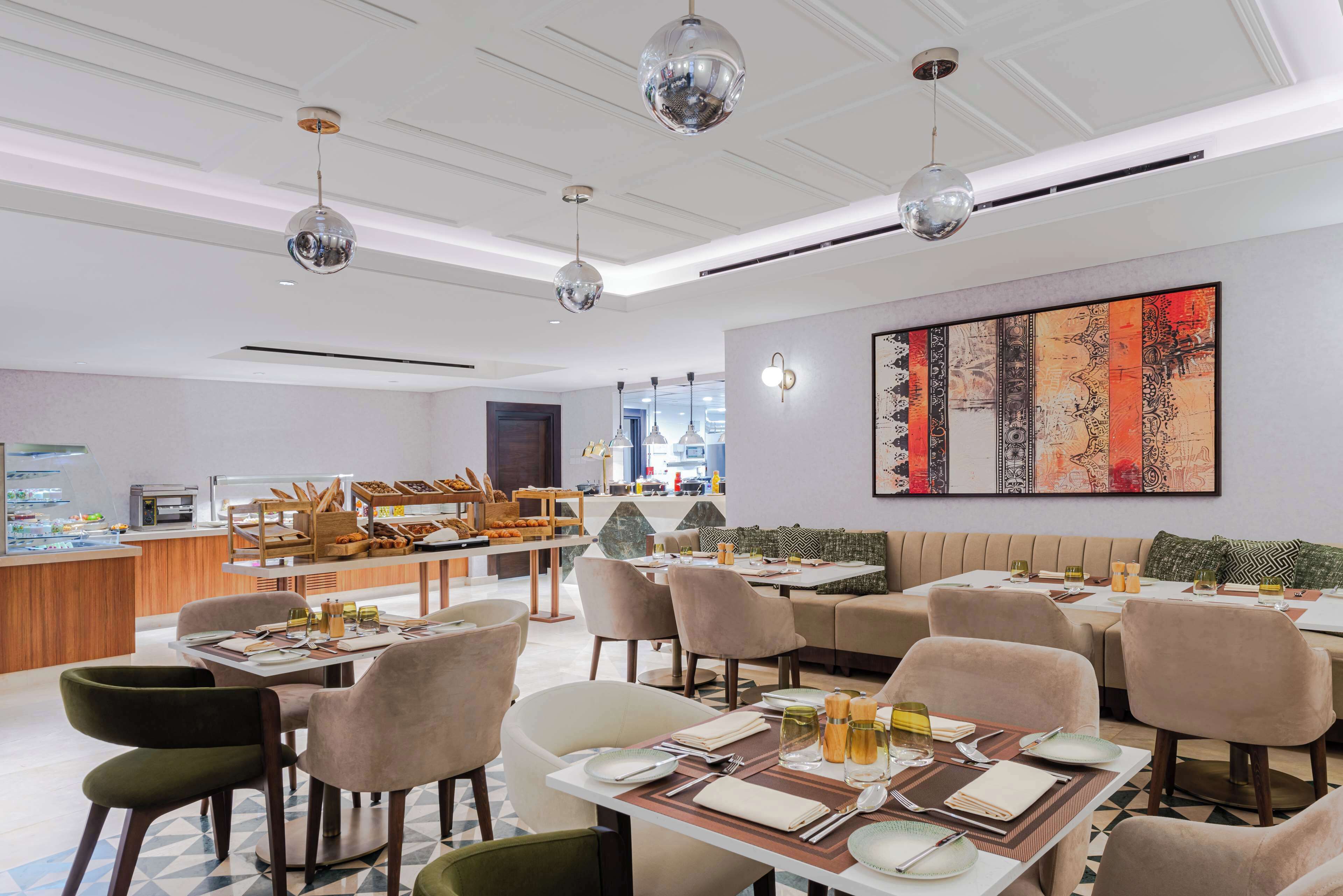 En modern restaurang med flera olika matplatser, inklusive en bar och sittplatser för gästerna.