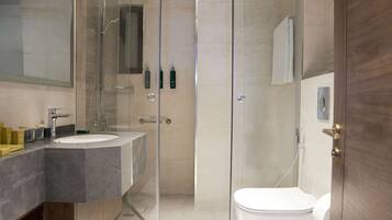 A modern bathroom with a glass-enclosed shower, a double sink vanity, and a toilet.