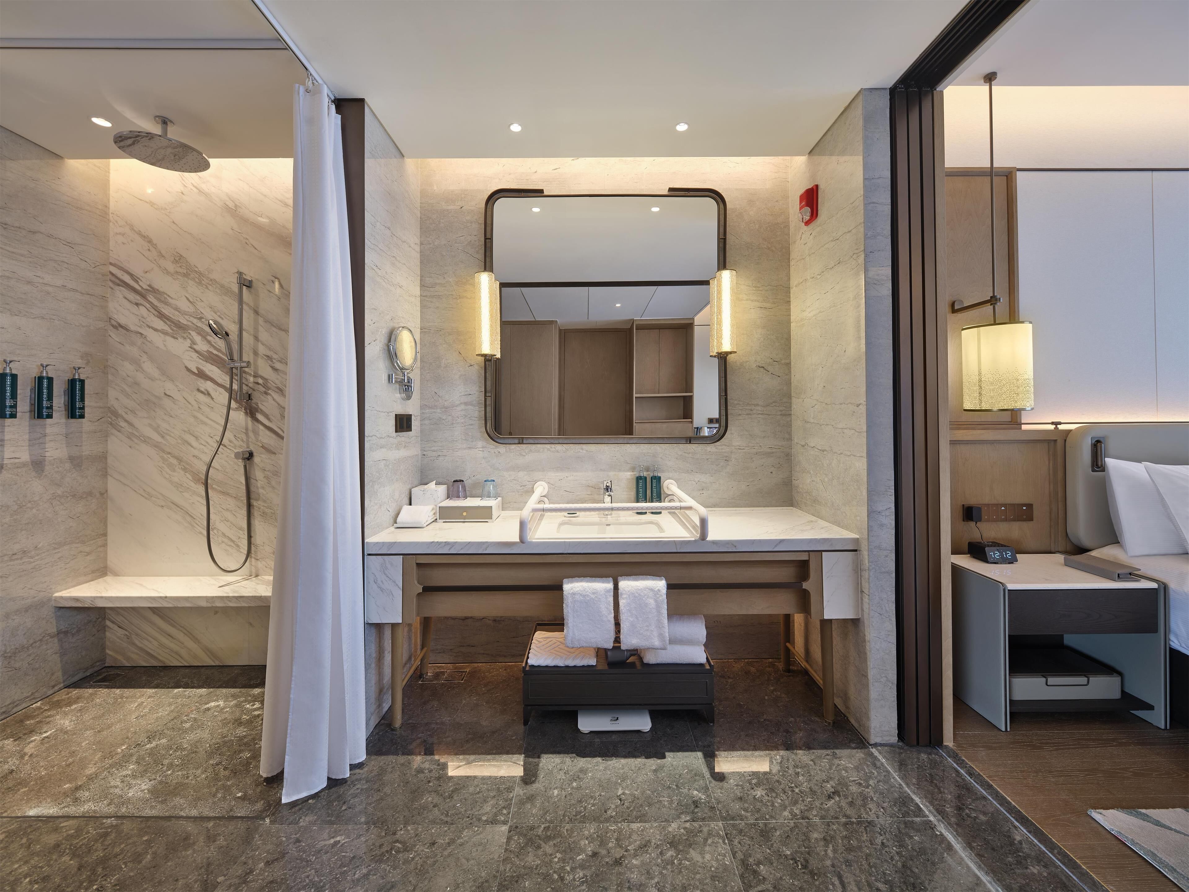 Un baño moderno con ducha, lavamanos y espejo.