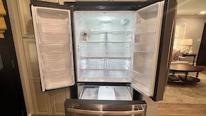 Ein Edelstahl-Kühlschrank mit zwei geöffneten Türen, die den Innenraum zeigen.