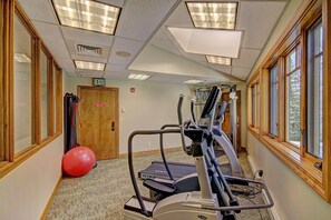 A fitness room with treadmills, a red exercise ball, and a door marked "EXIT".