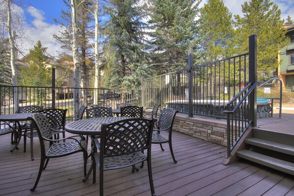 A deck with outdoor seating and a staircase leading to a building.