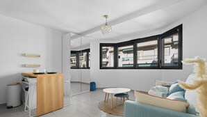 A modern living room with a wooden desk, a sofa, and a dining table. - Studio Amanda - Welkeys (Nice)