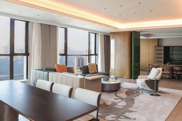 A modern living room with a large window, a sofa set, a dining area, and a kitchen. - Holiday Inn Hotel and Suites Chongqing Nanan by IHG (Chongqing)
