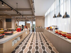 A modern cafe with a long counter, multiple seating areas, and a patterned floor. - Holiday Inn Express Taizhou Toumen Port by IHG (Taizhou)