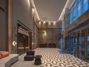 A spacious lobby with a geometric patterned floor, a modern chandelier, and a reception desk. - Holiday Inn Express Taizhou Toumen Port by IHG (Taizhou)