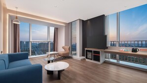 Una sala de estar moderna con un sofá, una mesa de centro, televisor y un balcón con vistas a la ciudad.