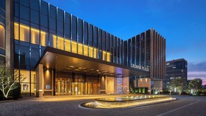 A modern hotel entrance with a glass facade, a central fountain, and a sign reading "Crowne Plaza". - Crowne Plaza Jingmen by IHG (Jingmen)