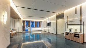 Un'ampia hall con pavimento lucido, una reception e un'area salotto.