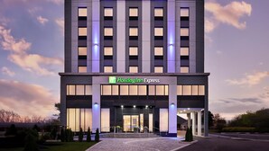A Holiday Inn Express hotel with a modern facade, large windows, and a well-lit entrance.
