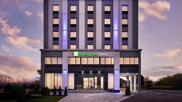 A Holiday Inn Express hotel with a modern facade, large windows, and a well-lit entrance. - Holiday Inn Express Hamilton Upper James by IHG (Hamilton)