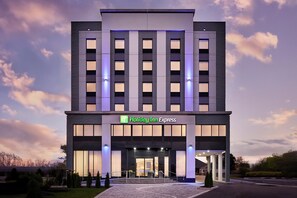 A Holiday Inn Express hotel with a modern facade, large windows, and a well-lit entrance.