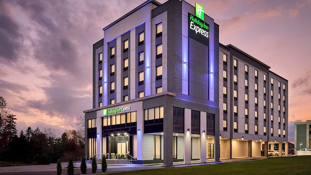 A Holiday Inn Express hotel with a modern facade, multiple entry points, and a parking area.