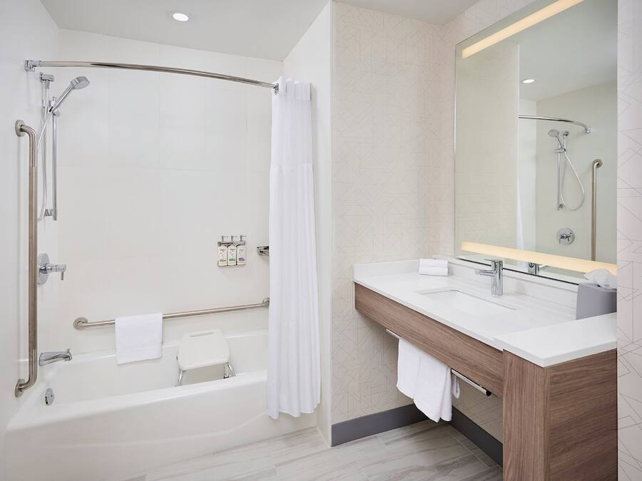 A modern bathroom with a walk-in shower, a bathtub, and a vanity with a mirror.